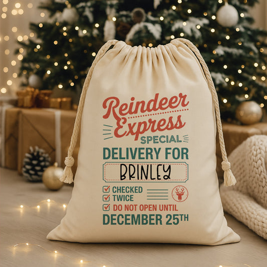 Personalized Christmas gift sack with 'Reindeer Express' text in front of a decorated Christmas tree.